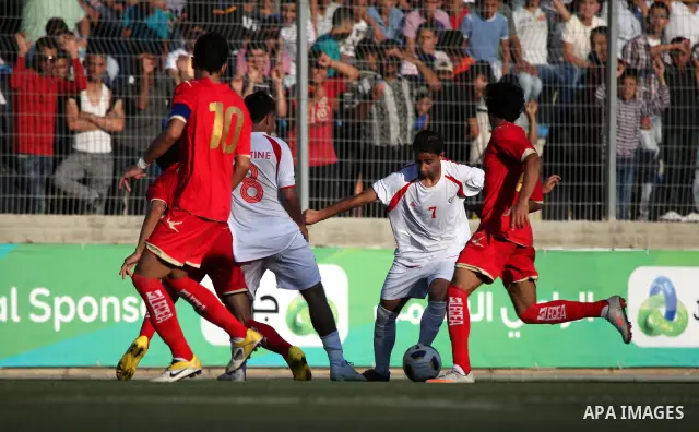 Palestinian team's player challenges the Bahrain's player during their 2012 Olympic qualifying football match in the West Bank town of Al-Ram, near Ramallah, on June 23, 2011 . Photo by Issam Rimawi