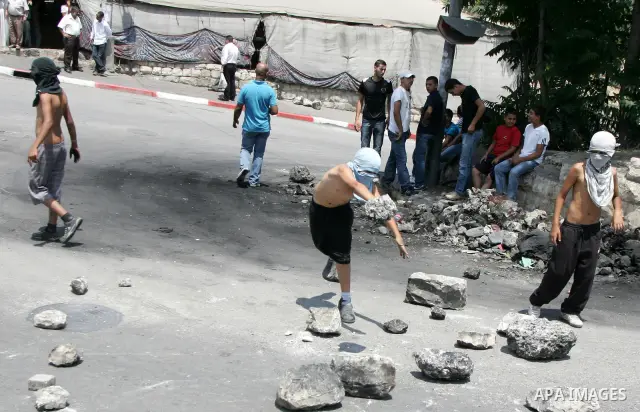 Masked Palestinian youths close the road with stones in front of the Israeli forces outside the protest tent in the east Jerusalem neighborhood of Silwan on June 24, 2011.. Photo by Mahfouz Abu Turk