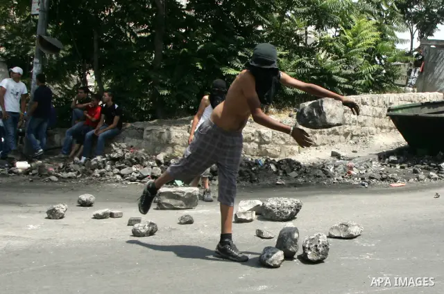 Masked Palestinian youths close the road with stones in front of the Israeli forces outside the protest tent in the east Jerusalem neighborhood of Silwan on June 24, 2011.. Photo by Mahfouz Abu Turk