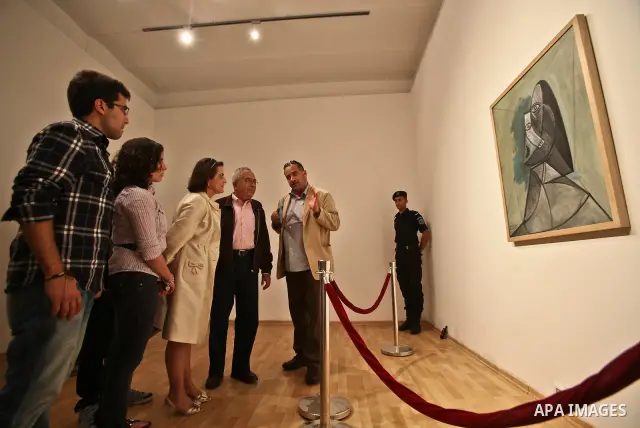 Palestinian Prime minister Salam Fayyad (C-L) and his family look at Picasso's 1943 canvas "Buste de Femme" which was lent by The Van Abbe museum in Eindhoven to the Palestinian Art Academy museum in the West Bank city o...