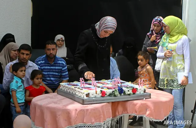 A relative of a Palestinian prisoner held in an Israeli jail watches a Palestinain playing the role of Israeli soldier Gilad Shalit to mark the fifth anniversary of Shalit's capture by Palestinian militants, in Jabalya i...