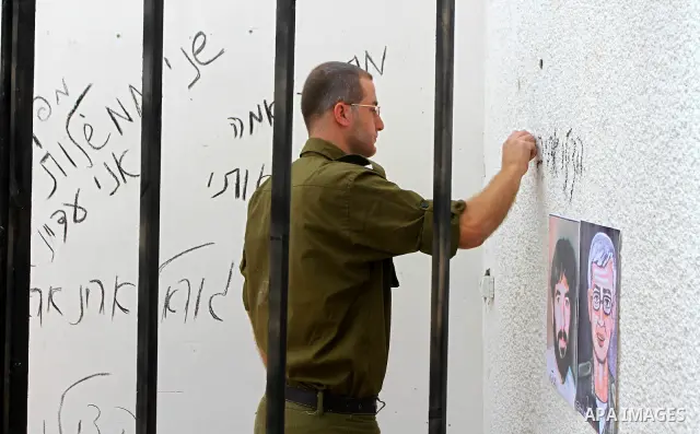 A Palestinian playing the role of Israeli soldier Gilad Shalit stands in a cage to mark the fifth anniversary of his capture by Palestinian militants, in Jabalya in the northern Gaza Strip June 25, 2011. The Hebrew writi...