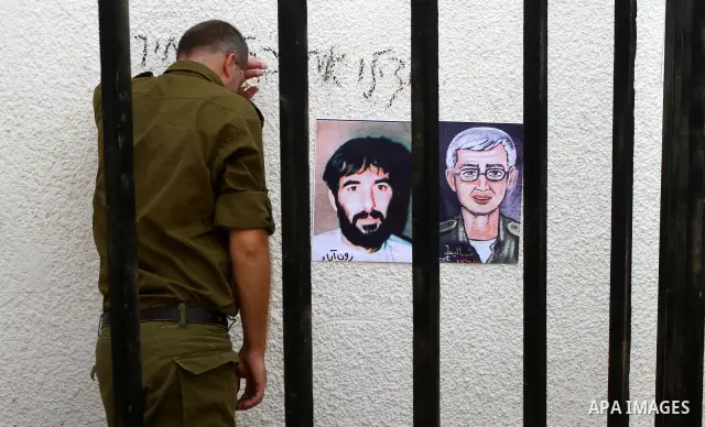 A Palestinian playing the role of Israeli soldier Gilad Shalit stands in a cage to mark the fifth anniversary of his capture by Palestinian militants, in Jabalya in the northern Gaza Strip June 25, 2011. The Hebrew writi...