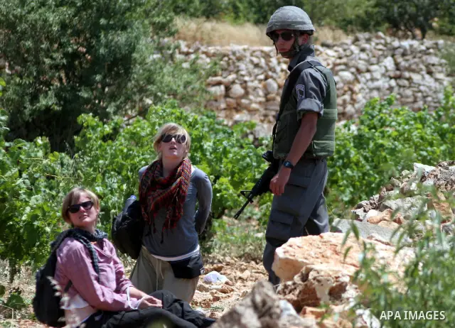 Israeli soldiers detain foreign activists during a demonstration against the demolishing of farm land to be used in the construction of Jewish settlements near the existing Israeli settlement of Karmi Tsor near the Pales...