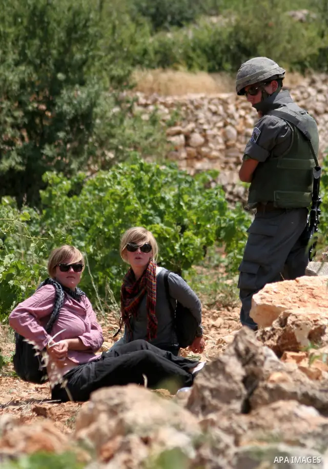 Israeli soldiers detain foreign activists during a demonstration against the demolishing of farm land to be used in the construction of Jewish settlements near the existing Israeli settlement of Karmi Tsor near the Pales...