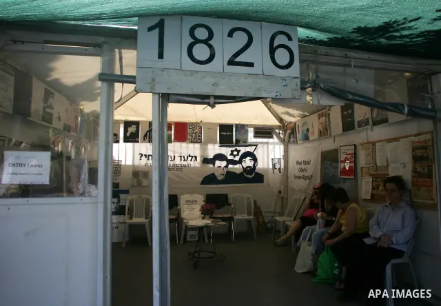 Israelis sit at the family's protest tent of abducted Israeli soldier Gilad Shalit near Prime Minister Benjamin Netanyahu's residence in Jerusalem on June 25, 2011 as Israelis mark the 1,826th day (5th year) of his capti...