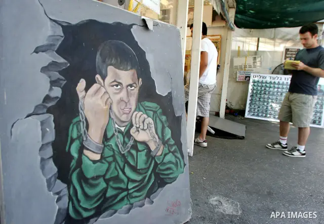 Israelis sit at the family's protest tent of abducted Israeli soldier Gilad Shalit near Prime Minister Benjamin Netanyahu's residence in Jerusalem on June 25, 2011 as Israelis mark the 1,826th day (5th year) of his capti...