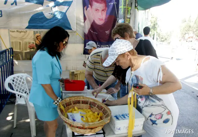 Israelis sit at the family's protest tent of abducted Israeli soldier Gilad Shalit near Prime Minister Benjamin Netanyahu's residence in Jerusalem on June 25, 2011 as Israelis mark the 1,826th day (5th year) of his capti...