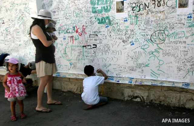 Israelis stand near the family's protest tent of abducted Israeli soldier Gilad Shalit near Prime Minister Benjamin Netanyahu's residence in Jerusalem on June 25, 2011 as Israelis mark the 1,826th day (5th year) of his c...
