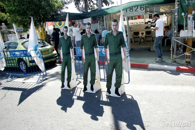 Israelis walk near the family's protest tent of abducted Israeli soldier Gilad Shalit near Prime Minister Benjamin Netanyahu's residence in Jerusalem on June 25, 2011 as Israelis mark the 1,826th day (5th year) of his ca...