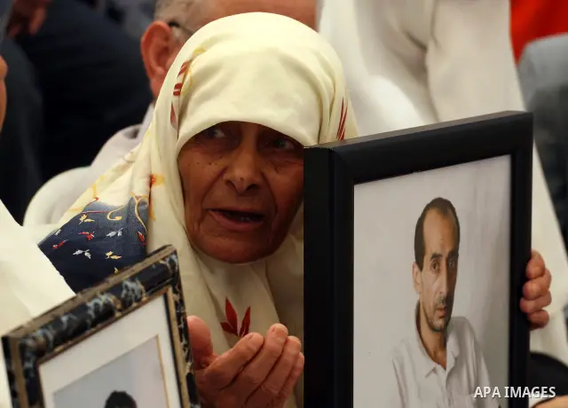 Palestinians hold pictures of relatives jailed in Israel during a protest against Israeli Prime Minister Benjamin Netanyahu's decision to worsen the prisoners holding conditions on Jun 26,2011, outside the International...