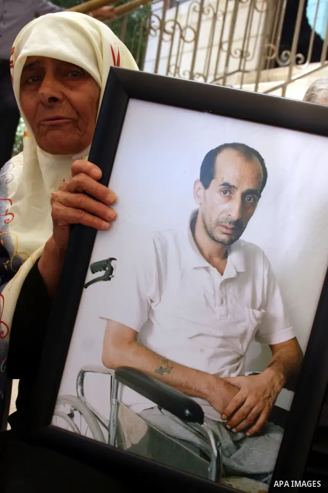 Palestinians hold pictures of relatives jailed in Israel during a protest against Israeli Prime Minister Benjamin Netanyahu's decision to worsen the prisoners holding conditions on Jun 26,2011, outside the International...