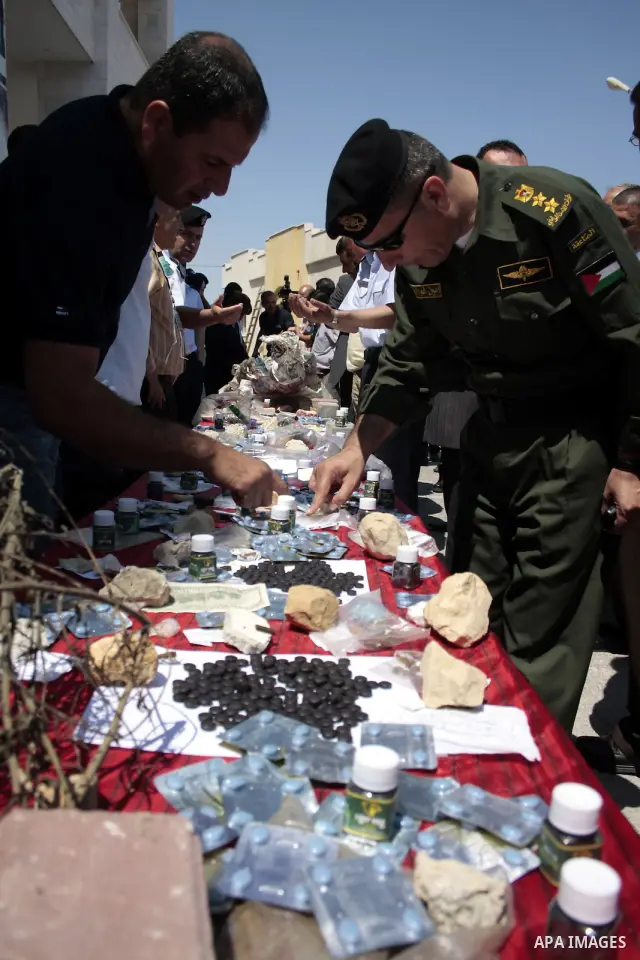 Palestinian police officers display the confiscated drugs which include heroin, opium and marijuana during a campaign against illegal drugs in the West Bank city of Hebron, 26 June 2011. Photo by Najeh Hashlamoun ..