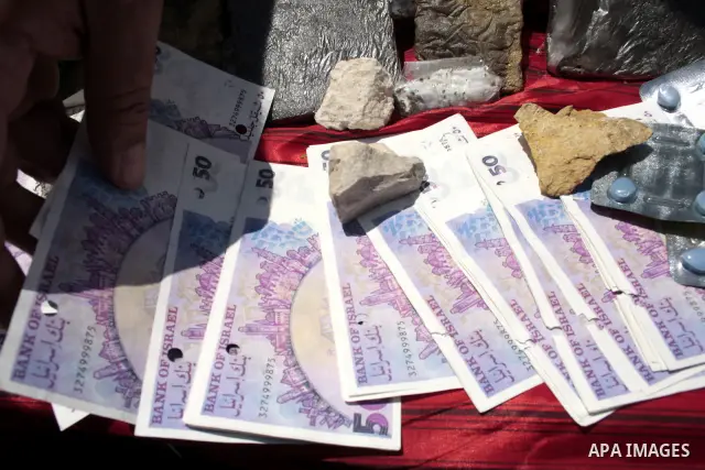 Palestinian police officers display the confiscated drugs which include heroin, opium and marijuana during a campaign against illegal drugs in the West Bank city of Hebron, 26 June 2011. Photo by Najeh Hashlamoun ..