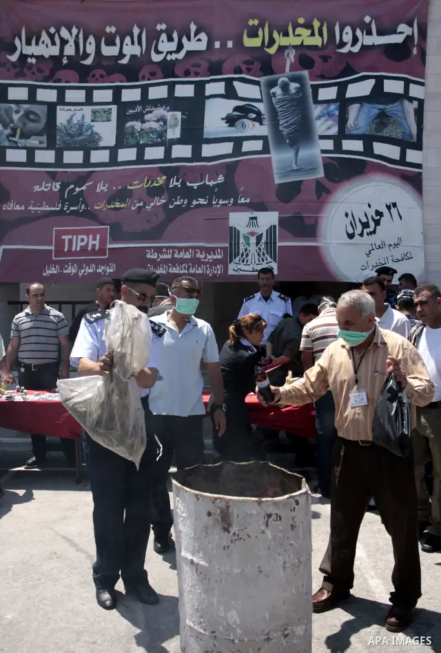 Palestinian police officers burn the confiscated drugs which include heroin, opium and marijuana during a campaign against illegal drugs in the West Bank city of Hebron, 26 June 2011. Photo by Najeh Hashlamoun ..