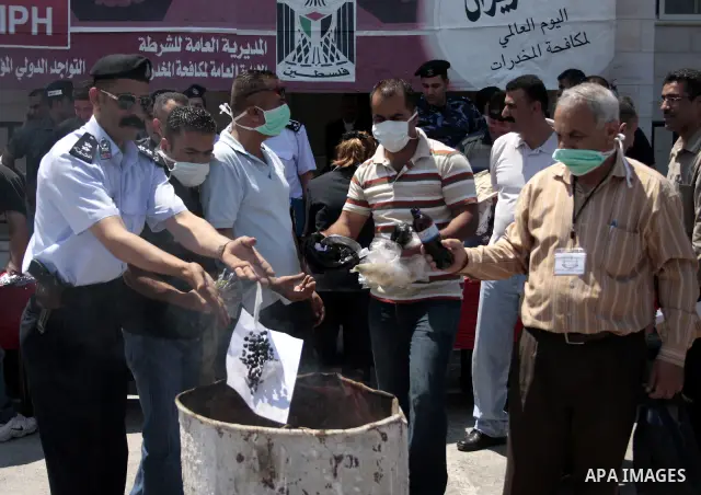 Palestinian police officers burn the confiscated drugs which include heroin, opium and marijuana during a campaign against illegal drugs in the West Bank city of Hebron, 26 June 2011. Photo by Najeh Hashlamoun ..