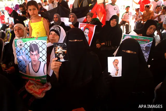 Palestinian women hold pictures of relatives during a protest calling for the release of Palestinian prisoners from Israeli jails in front of the Red Cross in Gaza city on June 26, 2011. Photo by Ashraf Amra