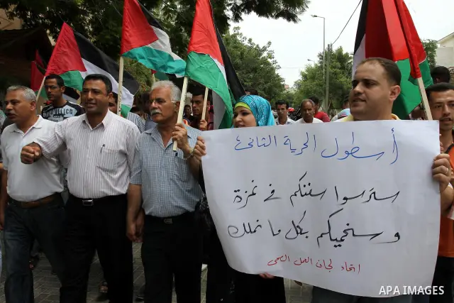 Palestinians from NGOs hold national flags and banners during a protest in solidarity with freedom flotilla "2" and to break the seige in front of the UNRWA in Gaza city on June 27, 2011. Photo by Mohammed Asad