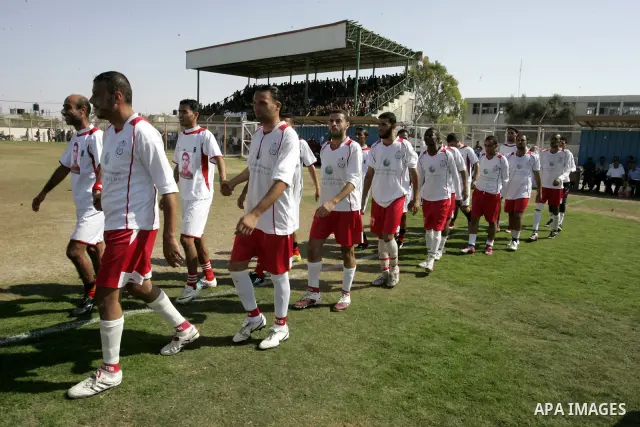 Palestinian football players prepare for a football match between Khan Yunis Youth club (red shirt) and Rafah Collective club (white shirt) on Jun 27, 2011 in the southern Gaza Strip town of Rafah. Photo by Abed Rahim Kh...