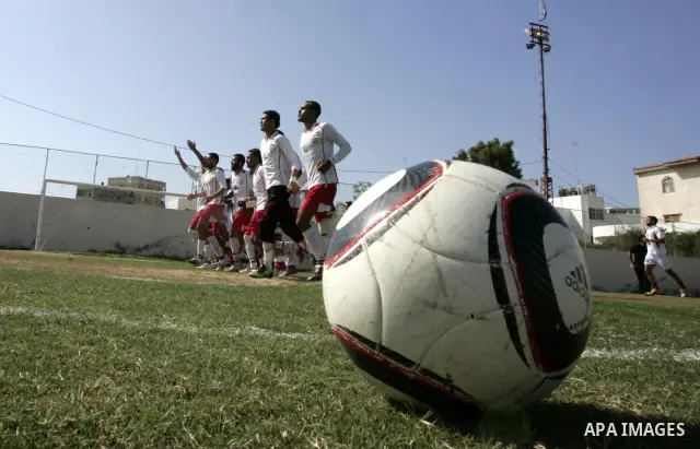 Palestinian football players prepare for a football match between Khan Yunis Youth club (red shirt) and Rafah Collective club (white shirt) on Jun 27, 2011 in the southern Gaza Strip town of Rafah. Photo by Abed Rahim Kh...