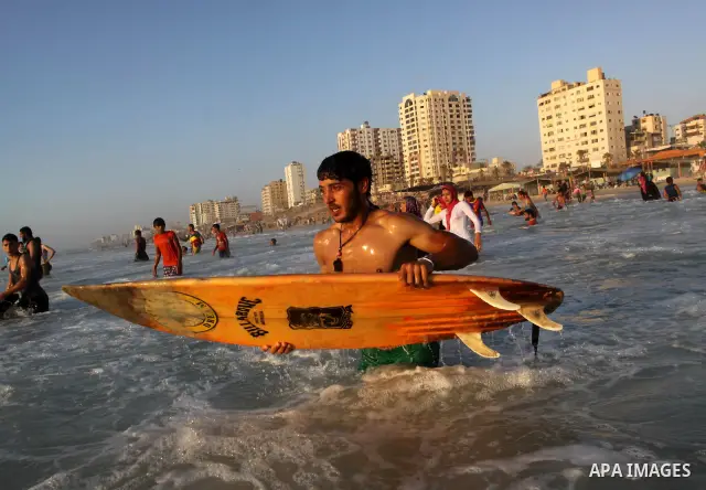 A Palestinian surfer rides a wave in Gaza City on Jun 28,2011. Photo by Mohammed Asad