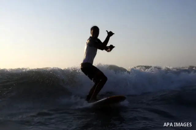 A Palestinian surfer rides a wave in Gaza City on Jun 28,2011. Photo by Mohammed Asad