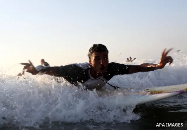 A Palestinian surfer rides a wave in Gaza City on Jun 28,2011. Photo by Mohammed Asad