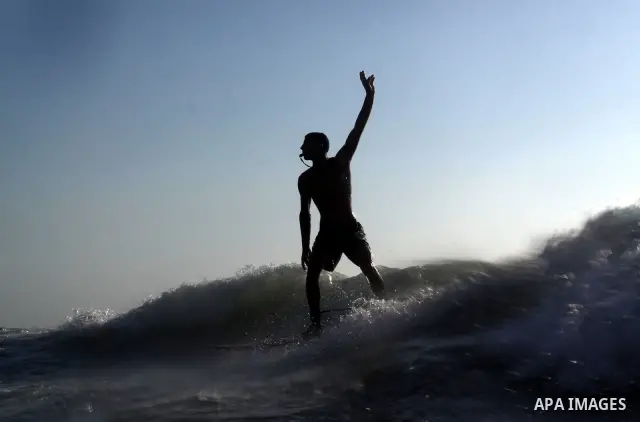 A Palestinian surfer rides a wave in Gaza City on Jun 28,2011. Photo by Mohammed Asad