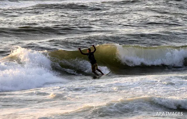 A Palestinian surfer rides a wave in Gaza City on Jun 28,2011. Photo by Mohammed Asad