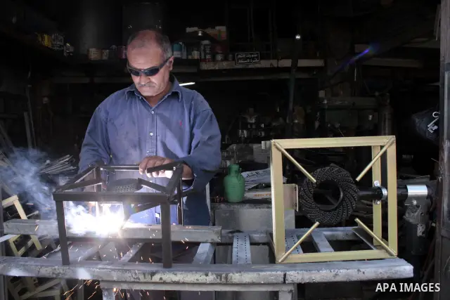 A Palestinian elderly man Elias Abdel-Hay works at his shop as he prepare to study in the high school "Twajihi" after he left studing for 47 years old in the West Bank city of Hebron on June 29, 2011. Where he completed...