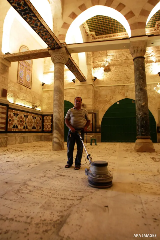 A Palestinian man cleans the floor inside the Al-Aqsa Mosque in Jerrusalem's old city on June 29, 2011 to prepare it for the fitting of a new carpet. According to Sheikh Azzam Khatib, the head of the Islamic Waqf in Jeru...
