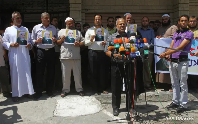 Supporters of Sheikh Raed Salah (portrait), head of the radical wing of the Islamic Movement in Israel, resport a speech during a demonstrate in Gaza City on June 30, 2011 after the controversial Arab-Israeli Islamist le...