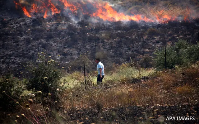 Palestinian villagers put out a burning field which according to witnesses was set ablaze by Jewish settlers on June 30, 2011 in the Israeli-occupied Palestinian West Bank village of Hawara. Photo by Wagdi Eshtayah