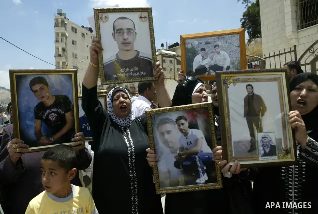 Palestinians women hold pictures of their relatives, during a protest calling for the release of Palestinian prisoners from Israeli jails, in the West Bank city of Nablus Thursday, June 30, 2011. Israel currently holds a...