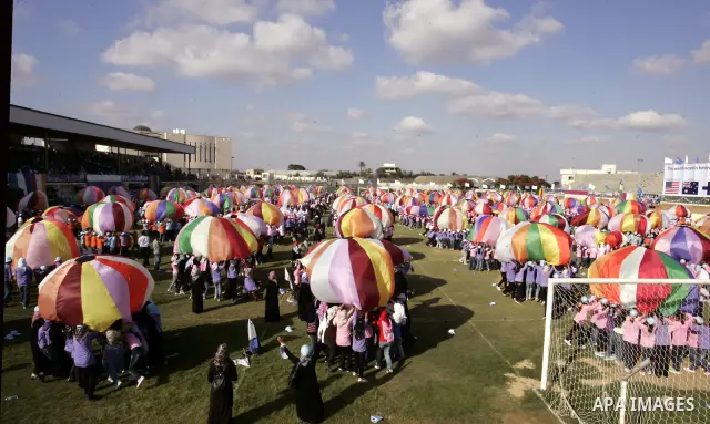 Palestinian children perform with coloured parachutes during summer camp activities supervised by the UN Relief and Works Agency (UNRWA) in Khan Yunis in the southern Gaza Strip on June 30, 2011. Photo by Abed Rahim Khat...