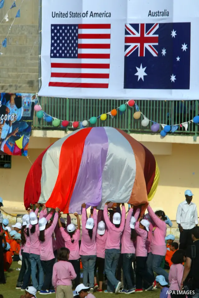 Palestinian children perform with coloured parachutes during summer camp activities supervised by the UN Relief and Works Agency (UNRWA) in Khan Yunis in the southern Gaza Strip on June 30, 2011. Photo by Abed Rahim Khat...