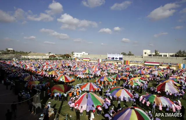 Palestinian children perform with coloured parachutes during summer camp activities supervised by the UN Relief and Works Agency (UNRWA) in Khan Yunis in the southern Gaza Strip on June 30, 2011. Photo by Ali Jadallah