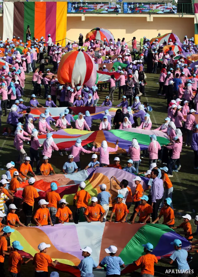 Palestinian children perform with coloured parachutes during summer camp activities supervised by the UN Relief and Works Agency (UNRWA) in Khan Yunis in the southern Gaza Strip on June 30, 2011. Photo by Ali Jadallah