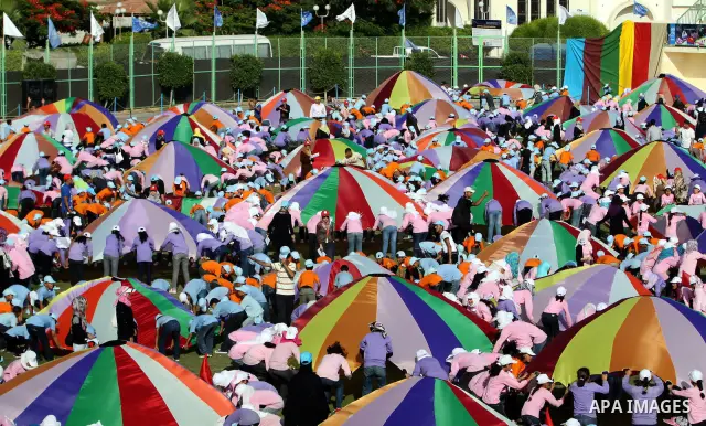Palestinian children perform with coloured parachutes during summer camp activities supervised by the UN Relief and Works Agency (UNRWA) in Khan Yunis in the southern Gaza Strip on June 30, 2011. Photo by Ali Jadallah