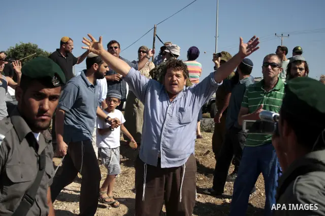 Israeli soldiers and an Israeli settler argue as security forces evacuate a group of Jewish settlers who tried to make a sit-in on a Palestinian land that was being cultivated by Palestinian farmers, on July 1, 2011 in t...
