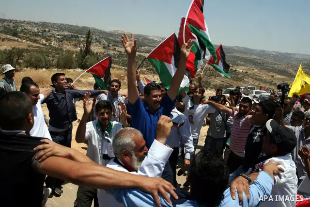 Palestinian demonstrators celebrate at the site where Israeli forces ripped down part of its controversial separation barrier outside the West Bank village of Bilin, the focus of anti-barrier protests, on July 1, 2011. I...