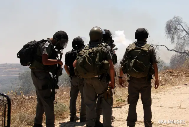 Israeli forces fire tear gas canisters during clashes with Palestinian villagers following a protest against the closure of a road during the second Intifada by Jewish settlers from the nearby settlement of Kadumim, on J...