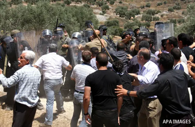 Israeli forces and Palestinian villagers scuffle during a protest against the closure of a road during the second Intifada by Jewish settlers from the nearby settlement of Kadumim , on July 01, 2011 in the West Bank vill...