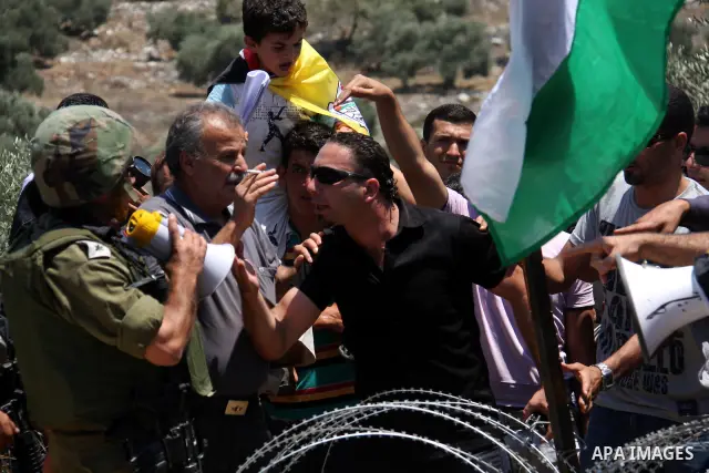 Israeli forces and Palestinian villagers scuffle during a protest against the closure of a road during the second Intifada by Jewish settlers from the nearby settlement of Kadumim , on July 01, 2011 in the West Bank vill...
