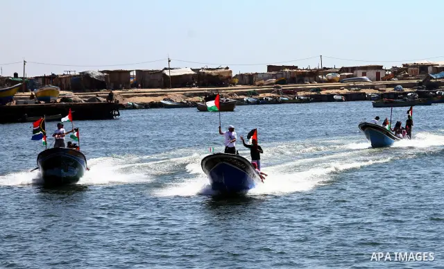Palestinians ride on boats at the port of Gaza City during a rally in support of the Gaza-bound international Freedom Flotilla hoping to breach Israel's sea blockade on Gaza as it was banned by Greece from setting sail o...