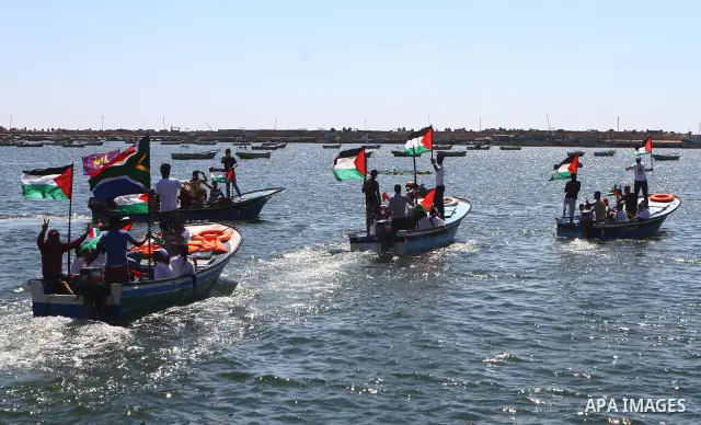Palestinians ride on boats at the port of Gaza City during a rally in support of the Gaza-bound international Freedom Flotilla hoping to breach Israel's sea blockade on Gaza as it was banned by Greece from setting sail o...