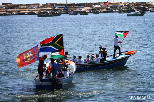 Palestinians ride on boats at the port of Gaza City during a rally in support of the Gaza-bound international Freedom Flotilla hoping to breach Israel's sea blockade on Gaza as it was banned by Greece from setting sail o...