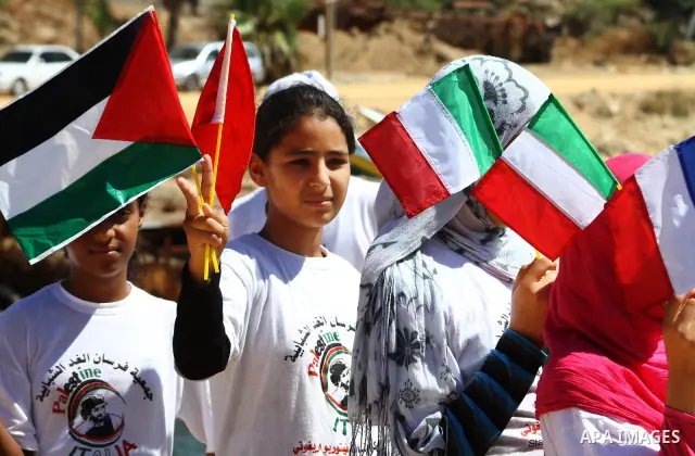 Palestinian children wave Palestinian flags along with the national flags of activists taking part in the Gaza-bound international Freedom Flotilla hoping to breach Israel's sea blockade on Gaza during a rally in Gaza Ci...