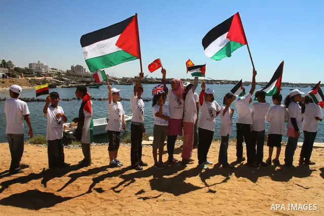 Palestinian children wave Palestinian flags along with the national flags of activists taking part in the Gaza-bound international Freedom Flotilla hoping to breach Israel's sea blockade on Gaza during a rally in Gaza Ci...