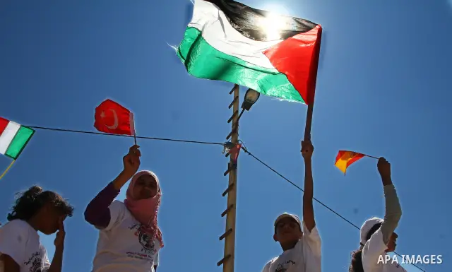 Palestinian children wave Palestinian flags along with the national flags of activists taking part in the Gaza-bound international Freedom Flotilla hoping to breach Israel's sea blockade on Gaza during a rally in Gaza Ci...